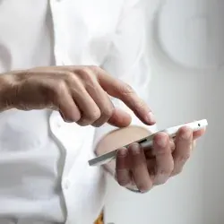 Un tanar apasa cu degetul pe un smartphone